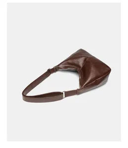 Detailansicht der retro braunen Schultertasche aus weichem Leder mit minimalistischem Design.