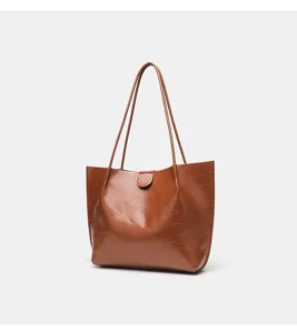 Borsa tote marrone in pelle PU lucida con texture stropicciata, manici lunghi e capiente.