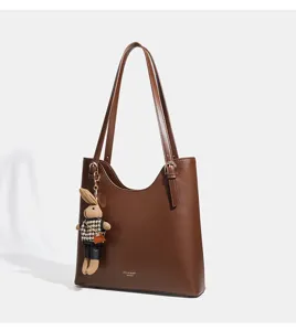 Vue détaillée du sac cabas en cuir marron montrant sa texture lisse et son charm lapin.