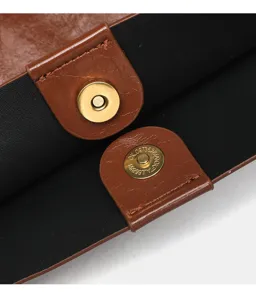 Primo piano dettagliato della chiusura magnetica e della ferramenta della borsa shopper in pelle PU.