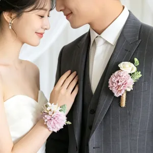 Close-up detail shot of elegant artificial carnation corsage and matching wrist flower set for wedding.
