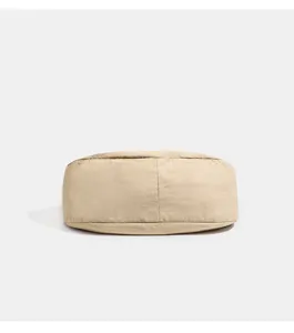 Unterseite der beigen wasserdichten Nylon Umhängetasche, Detailansicht des Bodens.