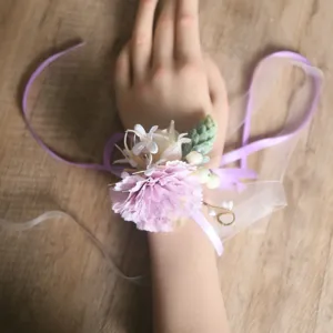 Detailed view of forest style artificial carnation wrist corsage in light pink for wedding.