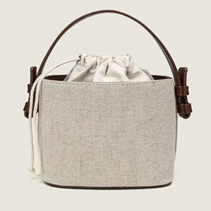 Elegante Damen Segeltuch Eimer Tasche mit braunem Ledergriff und sicherem Kordelzugverschluss.