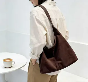 Braune Schultertasche aus Wildleder im Detail, große Hobo-Tasche für Alltag und Pendeln.