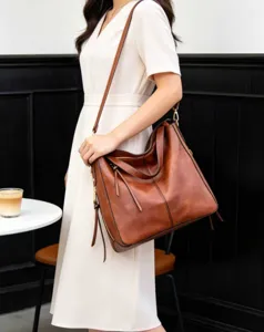 Vue de détail d'un sac hobo bandoulière marron en cuir souple vintage de grande capacité.