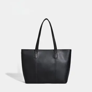 Detailed view of the classic black leather tote bag featuring sturdy handles and clean stitching.