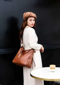 Vue détaillée d'un sac hobo bandoulière en cuir souple marron, style vintage élégant.