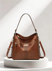 Nahaufnahme der braunen Weichleder Tasche mit perforierten Streifen und doppelten Taschen.