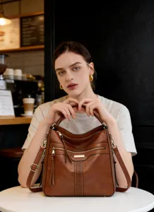 Detailansicht der braunen weichen Leder-Umhängetasche im Café, stilvolles Accessoire für jeden Tag.