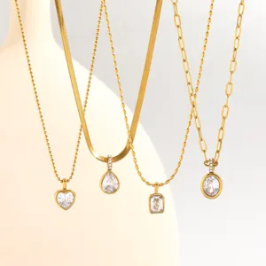 Close-up detail of layered gold stainless steel necklaces featuring sparkling cubic zirconia pendants.
