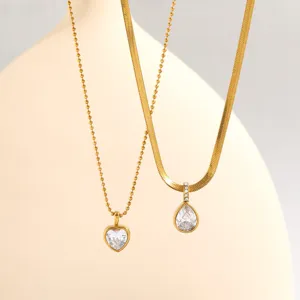 Close-up view of gold stainless steel layered necklaces featuring sparkling zirconia pendants.