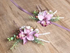 Detail view of the pink and purple artificial orchid wrist corsage and wedding boutonniere set.