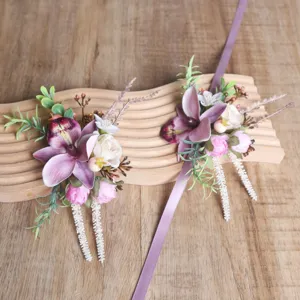 Detailed view of forest style purple artificial flower wrist corsage with ribbons, wedding floral.