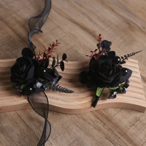 Vue détaillée de corsage et bracelet de roses noires artificielles gothiques avec ruban.