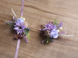 Gros plan détail de corsage de mariage de fleurs artificielles violettes et bracelet.