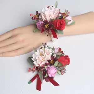 Detailansicht künstlicher Hochzeits-Blumenarmreif mit roter Rose, rosa Dahlie und Perlenarmband.