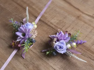 Détail de corsage de poignet et de boutonnière de fleurs artificielles violettes.