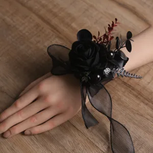 Corsage de poignet de rose artificielle noire gothique pour robe de mariage détail.