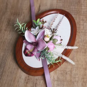 Forest style wedding corsage with purple orchid and green leaves for celebration.