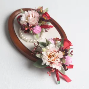 Detailansicht künstlicher Hochzeitskorsagen und Handgelenksblumen mit Rosen und Schleife.