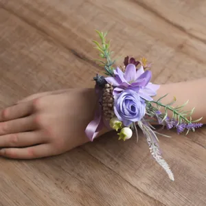 Corsage de poignet de fleurs artificielles violettes avec ruban, détail de mariage chic.