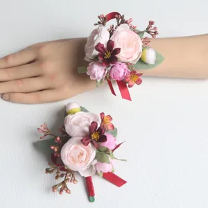 Künstliche Blumen Hochzeits Handgelenk Korsage und Ansteckblume mit rosa Rosen und roten Bändern.