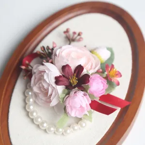 Elegantes Hochzeits-Armband mit rosa Rosen, Perlen und roter Schleife für Braut und Brautjungfern.