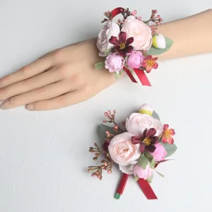 Künstliche Blumen Hochzeits Handgelenk Korsage Set mit rosa Rosen und roten Bändern.