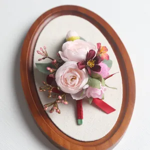 Nahaufnahme Detail der künstlichen Seidenblumen Hochzeits-Boutonniere mit roten Schleife.