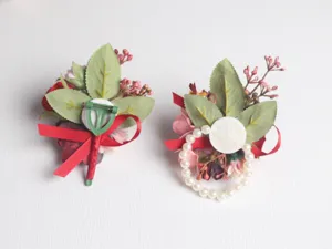 Detailansicht des künstlichen Hochzeitskorsags mit roten Rosen und weißen Perlen.