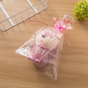 Roze pluche speelgoed pop in doorzichtige geschenkzak met strik, perfecte decoratie