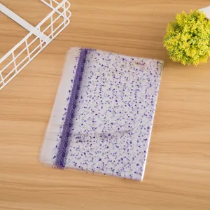 Transparent plastic packaging bag detail, featuring purple star and heart prints with lace trim.