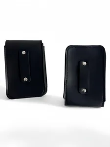 Black faux leather small pouch detail showing vertical strap and metallic snap buttons.