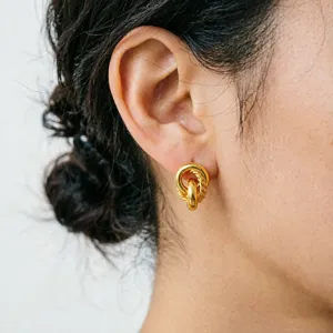 Detailed shot of elegant gold intertwined hoop earrings, vintage style for daily wear.