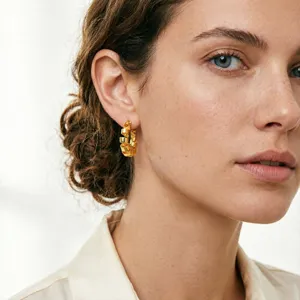 Close-up detail of vintage style textured gold hoop earrings worn by a model, elegant look.