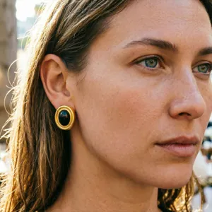 Detailed view of vintage gold-toned circular earrings featuring a black oval center stone.