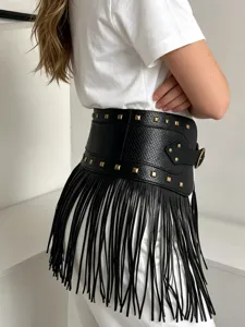 Detailed view of the wide black crocodile texture fringe belt with gold pyramid studs and buckle.