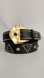 Black punk leather belt with gold geometric triangle rhinestone buckle and studded details.