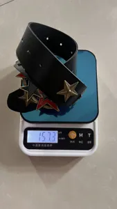 Punk style black leather belt detail featuring metallic bronze and red stars, weight showcase.