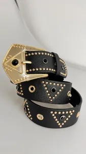 Punk style black leather belt with gold statement buckle, metal studs, and black rhinestones.