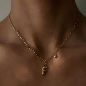 Detailaufnahme der vergoldeten Edelstahl Wellenkette Halskette mit Buchstaben F Anhänger.