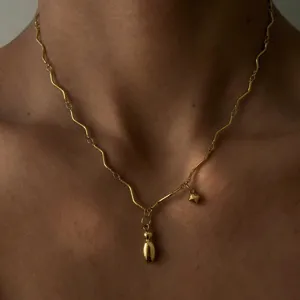 Nahaufnahme der Wellenkette aus Edelstahl mit einzigartigem vergoldeten Metallanhänger.