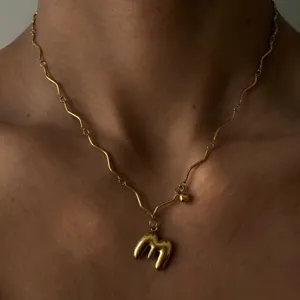 Vergoldete Edelstahl Halskette mit geometrischer Wellenkette und Ballon-Buchstaben-Anhänger.