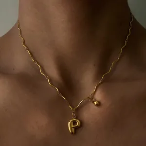 Detailansicht der vergoldeten Edelstahl Wellenkette mit Ballon Buchstabe P Anhänger am Hals.