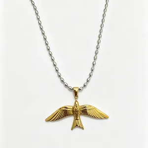 Vue détaillée d'un collier pendentif oiseau hirondelle doré tendance avec chaîne perles.
