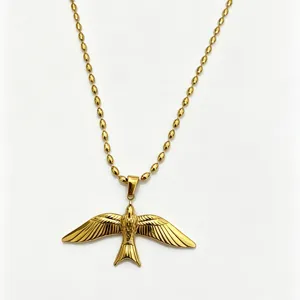 Gros plan du collier pendentif colombe volante dorée avec des détails de chaîne perles.