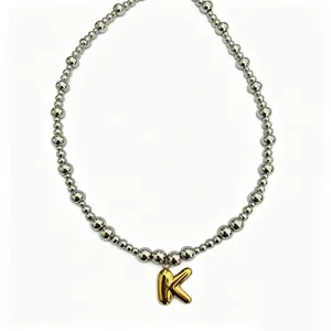 Close-up view of the trendy stainless steel beaded necklace with a gold puffy letter K charm.