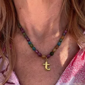 Detailed close-up view of the colorful beaded necklace featuring a glossy gold letter pendant.