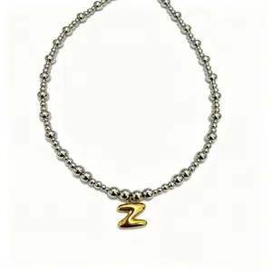 Stainless steel beaded necklace detail featuring a gold puffy letter Z pendant design.